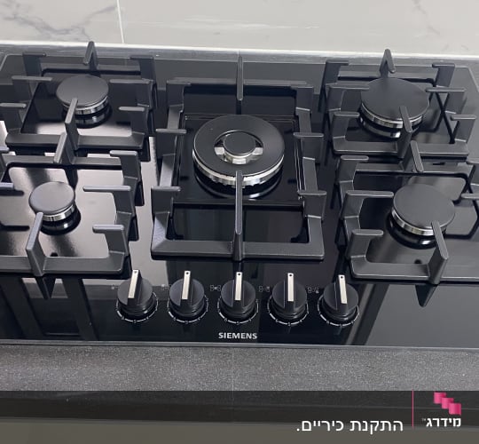 כיריים גז שחורות עם חמישה מבערים וכפתורי שליטה